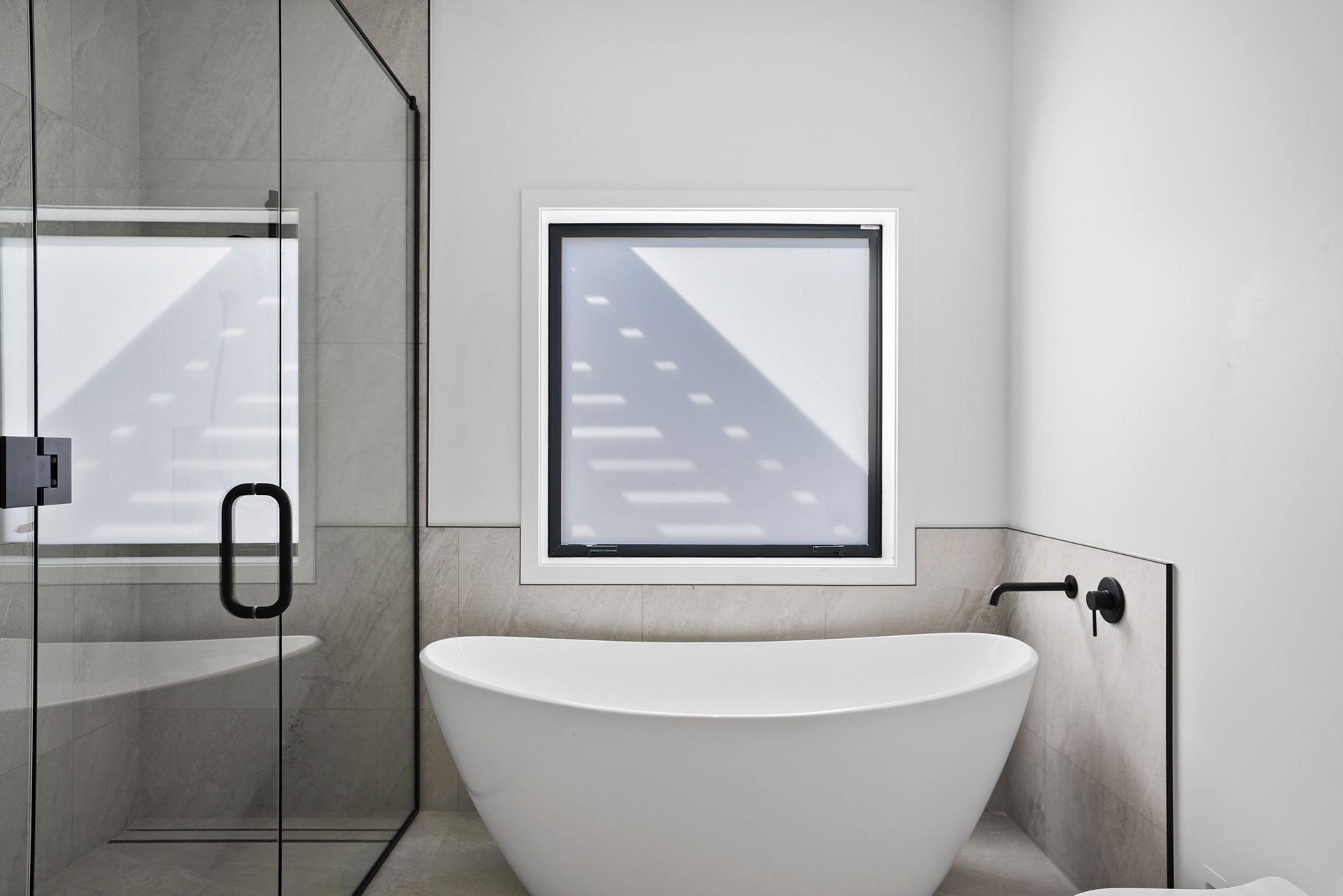 Modern tiled floor and wall tiles in a black and white contrasting bathroom scene